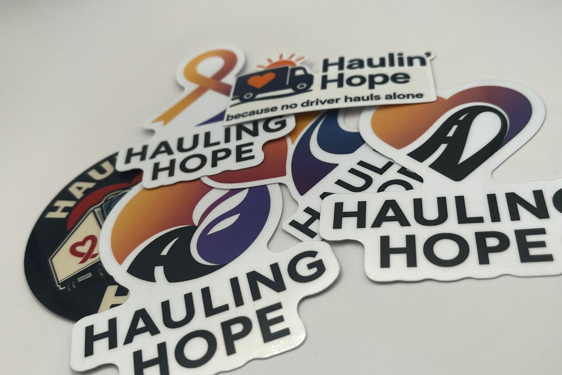 Stickers with 'Hauling Hope' branding on a light gray background