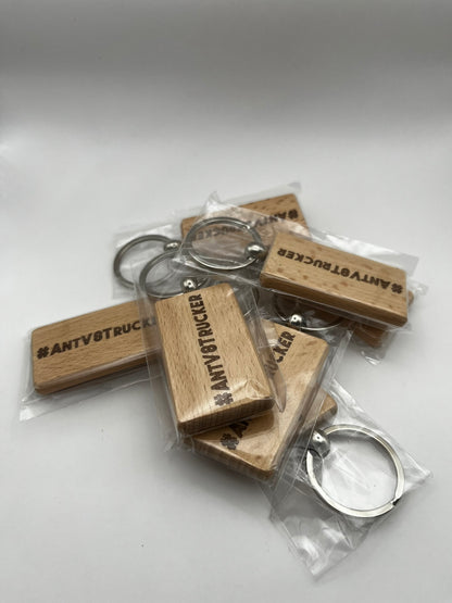 Wooden keychains with metal loops in clear packaging on a white background